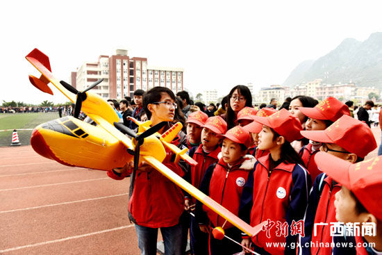 图为大学生给少年儿童讲解航模知识。 唐梦宪 摄